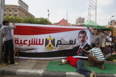 Supporters of Egyptian President Mohamed Mursi set up a banner as they take part in a protest to show support to him (Photo: Reuters)
