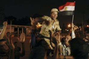 An army soldier (C) cheers with protesters, who are against Egyptian President Mohamed Morsi