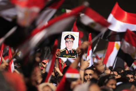 Protesters, who are against Egyptian President Mohamed Mursi, hold a poster featuring the head of Egypt's armed forces General Abdel Fattah al-Sisi