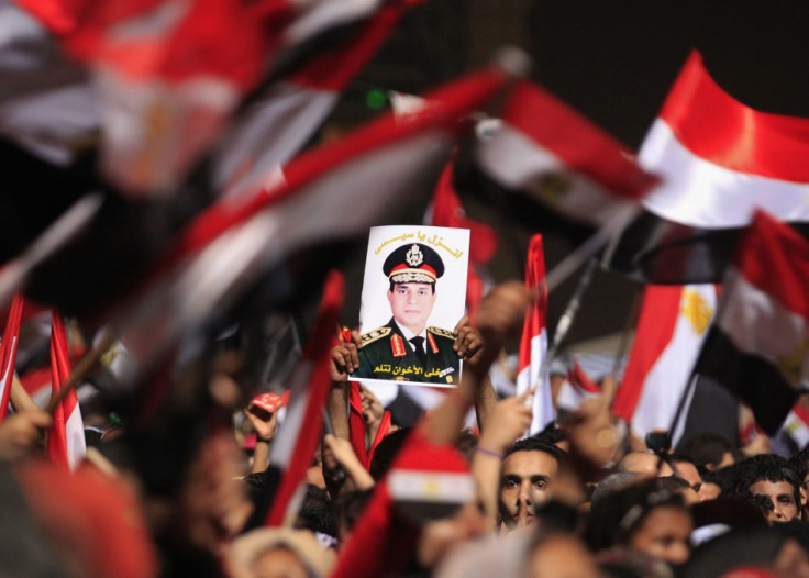 Protesters, who are against Egyptian President Mohamed Mursi, hold a poster featuring the head of Egypt's armed forces General Abdel Fattah al-Sisi