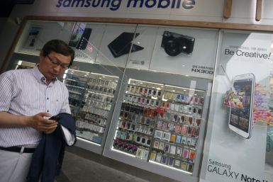 A man uses his mobile phone in front of a Samsung mobile shop in Seoul