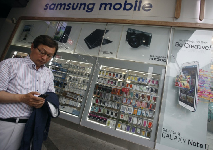 A man uses his mobile phone in front of a Samsung mobile shop in Seoul