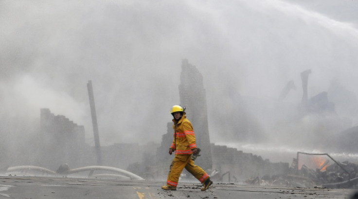 A firefighter walks past the smoking wreck