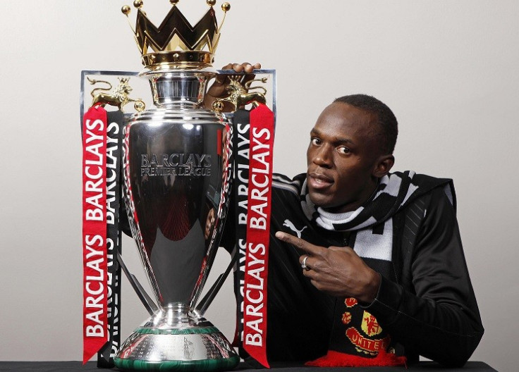 Usain Bolt poses in Man Utd scarf with Premier League trophy