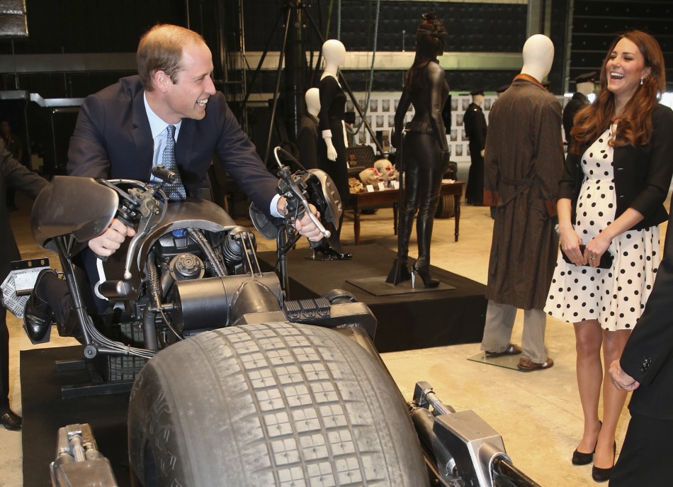 Catherine, Duchess of Cambridge, laughs as her husband Prince William sits on the Batpod, from a Batman film, during their visit to the Warner Bros. Studios at Leavesden in southern England April 26, 2013.