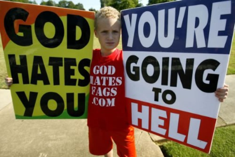 Indoctrinated child brandishes Westboro Baptist Church placards