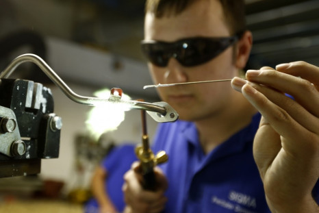 A worker brazes a component at a manufacturing firm in Hinckley, central England
