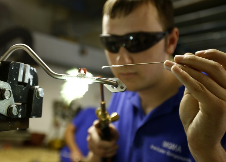 A worker brazes a component at a manufacturing firm in Hinckley, central England