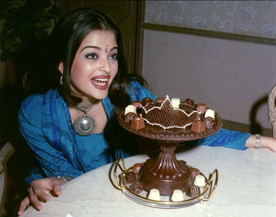 New Indian Miss World Aishwarya Rai looks longingly at a plate of chocolates shaped in a crown after returning to her home city of Bombay December 16
