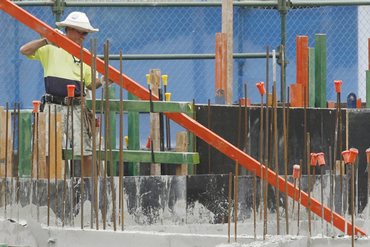 A man moves a plank of wood while working at a construction site for a mall in central Sydney