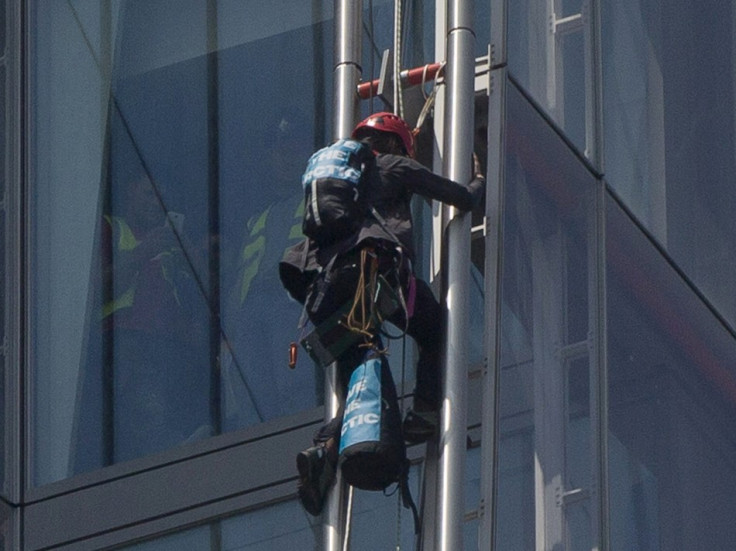 A Greenpeace demonstrator climbs the Shard building (Reuters)