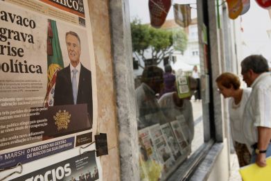 The headlines of the newspaper on the wall reads, "Cavaco deepens political crisis". (Photo: REUTERS)