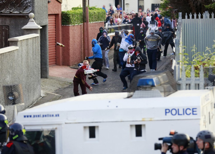 A rioter hurls a bottle at police during rioting in Woodvale, Belfast yesterday.