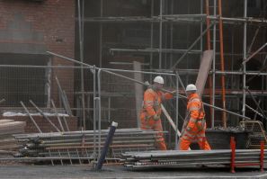 Workers carry scaffolding on a construction site in Chester, northern England