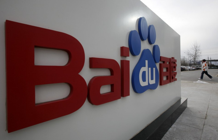 A woman walks past the company logo of Baidu at its headquarters in Beijing