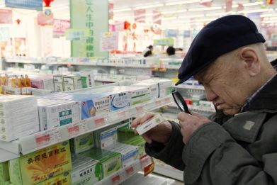 A customer casts a close eye over the product in a Chinese pharmacy