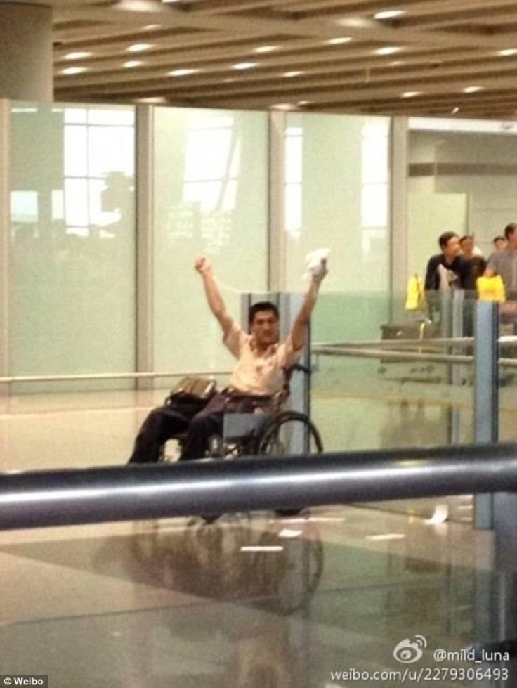 A man is pictured waving a package over his head minutes before an explosion at Beijing Airport.