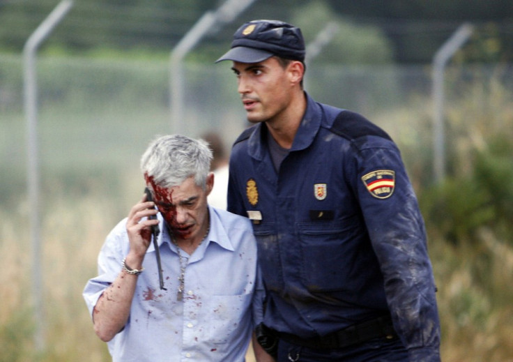 Francisco Jose Garzon Amo is led away by a police officer after the crash