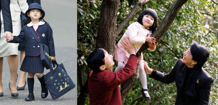 Japanese Princess Aiko plays on a tree as her father Crown Prince Naruhito and mother Crown Princess Masako watch in the garden of their residence, Togu Palace, in Tokyo on 17, November, 2004. Aiko is the only child of Japan's imperial heir Crown Prince N