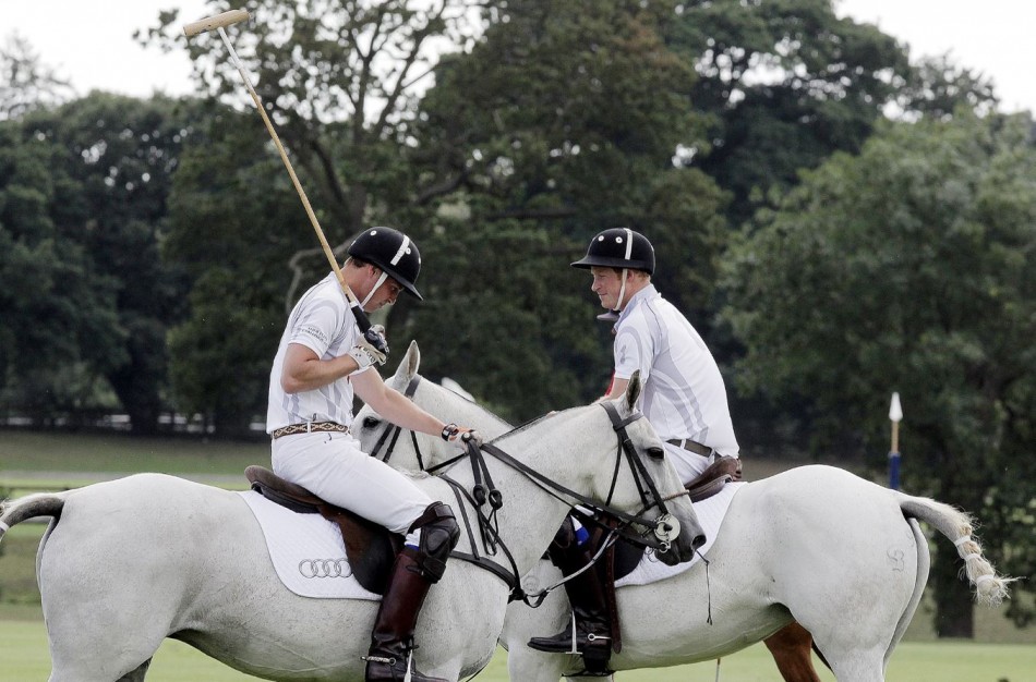 Prince Harry R speaks to Prince William during a charity polo match at Coworth Park, southern England August 3, 2013.