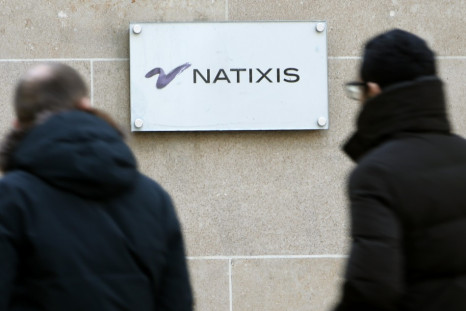People walk past the logo of French bank Natixis at one of their office in Paris