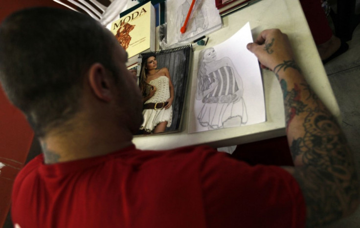 A prisoner draws a fashion model from a photograph. Guimaraes trained 18 prisoners on drawing, designing and knitting. (Photo: REUTERS/Paulo Whitaker)