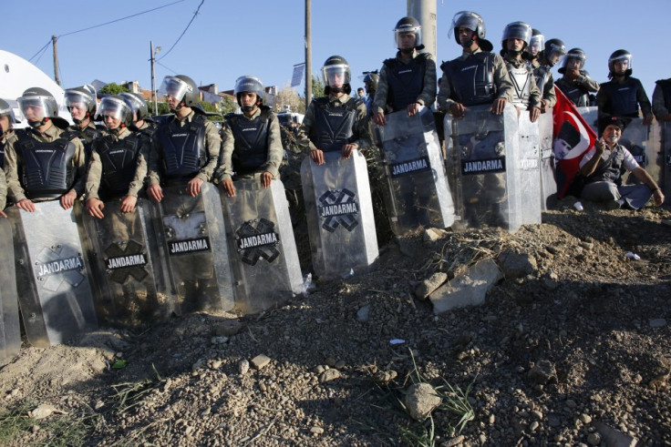 A protester sits in front of Turkish soldiers who prevented him from marching to a courthouse in Silivri