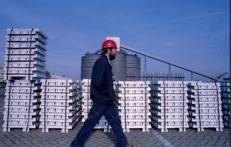 A worker passes by stocks of aluminium ingot