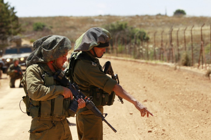 An Israeli army Lieutenant-Colonel (R) points as he stands with a another soldier during a patrol along Israel's border with Lebanon