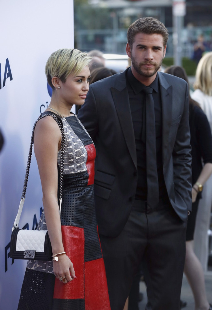 Liam Hemsworth poses with his fiancee, singer Miley Cyrus, at the premiere of "Paranoia" in Los Angeles, California August 8, 2013.