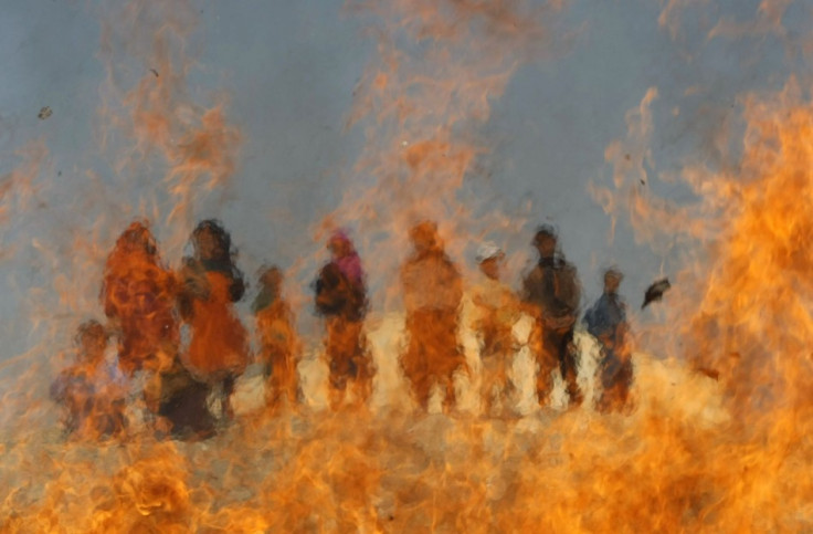 Afghan children watch burning expired medical items and food on the outskirts of Jalalabad, March 4, 2013. An Indian baby has been virtually in flames four times since his birth in May 2013 due to a rare condition called Spontaneous Human Combustion (Phot