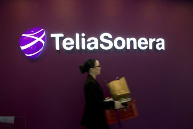 A woman walks past TeliaSonera's logo.