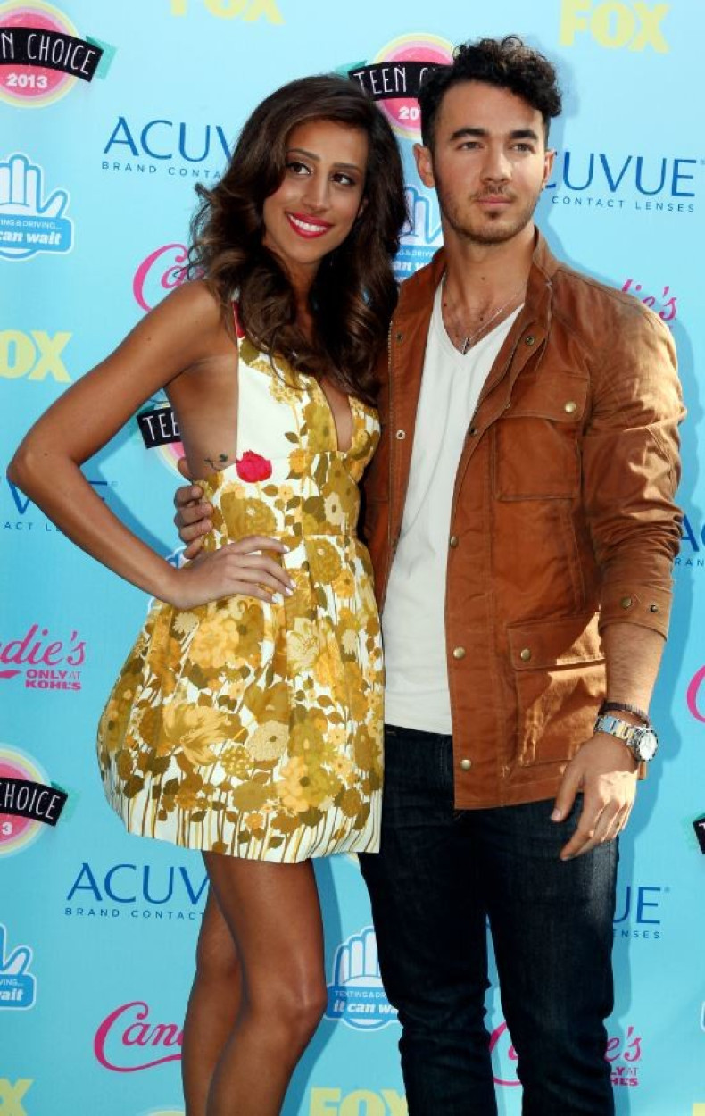 Singer Kevin Jonas and wife Danielle Deleasa pose as they arrive at the Teen Choice Awards at the Gibson amphitheatre in Universal City, California August 11, 2013.
