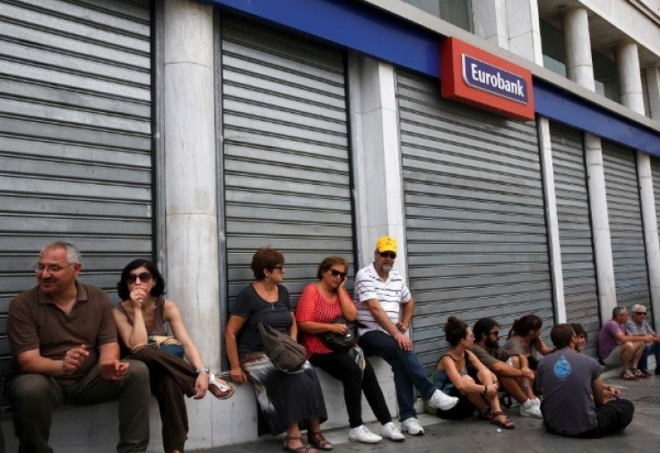 Anti-austerity protesters rest outside a closed bank during a rally in central Athens, Greece (Photo: Reuters)