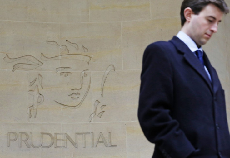 A man walks past a Prudential sign outside offices in the City of London