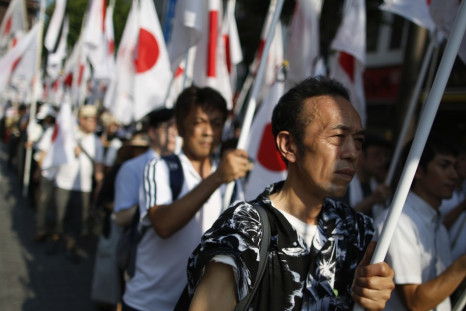Nationalist Ganbare Nippon members march with Japanese flags in tribute at Yasukuni Shrine in Tokyo