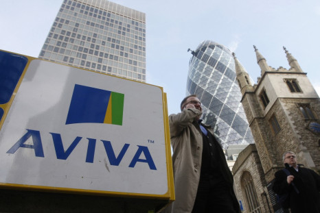 Pedestrians walk past an Aviva logo outside the company's head office in the city of London.