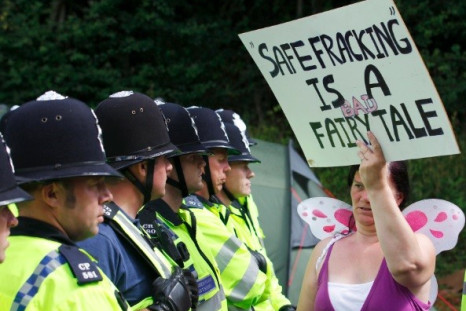 A demonstrator holds a sign that reads "Safe Fracking Is A Bad Fairy Tale" as police escort a lorry to a site run by Cuadrilla Resources, outside the village of Balcombe in southern England (Photo: Reuters)