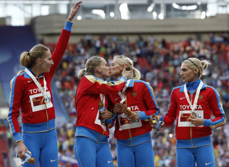 Gold medallists Kseniya Ryzhova and Tatyana Firova  kiss at the women's 4x400 metres relay victory ceremony during the IAAF World Athletics Championships at the Luzhniki stadium in Moscow