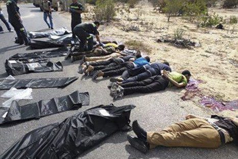 Army soldiers and medical workers check the bodies of police officers killed early morning on the highway in Rafah city