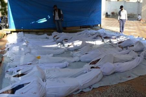 Syrian activists inspect the bodies of victims