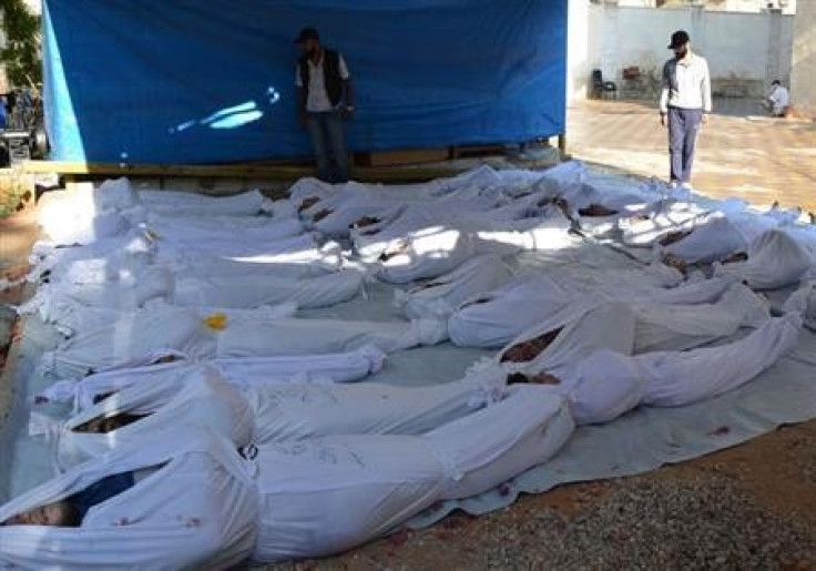 Syrian activists inspect the bodies of victims