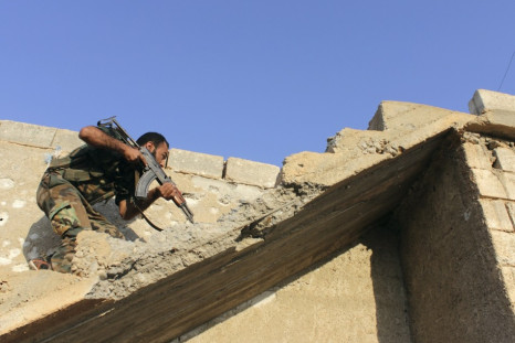 A Free Syrian Army fighter carries his weapon as he climbs on stairs
