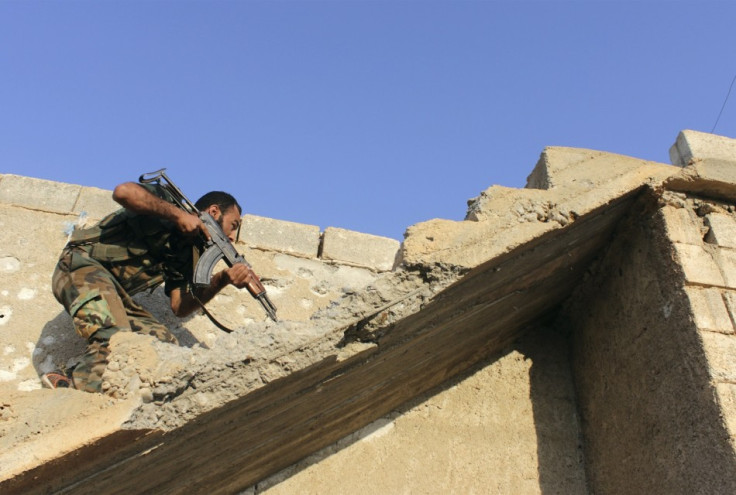 A Free Syrian Army fighter carries his weapon as he climbs on stairs