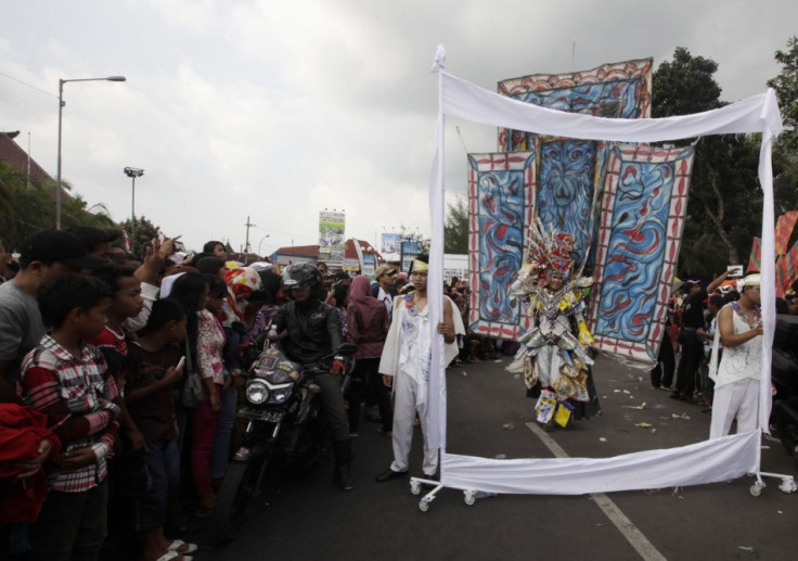 People gather at a street as a model, dressed in a costume, participates in the 12th Jember Fashion Carnival in Jember. (Reuters)