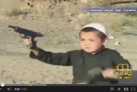 Screenshot of a video shows a boy firing guns from a pistol at Al-Qaida's terrorist camp in Afghanistan. (YouTube)