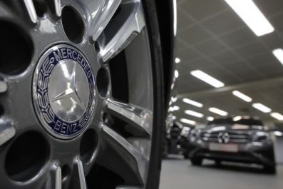 A company logo is seen on a wheel in front of Mercedes-Benz A-class cars displayed in a dealership of German car manufacturer Daimler in Paris (Reuters)