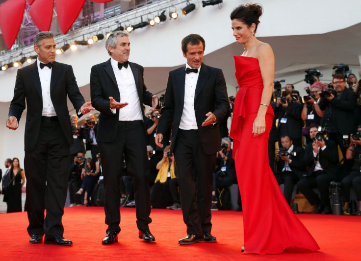 George Clooney, director Alfonso Cuaron (2nd L) and producer David Heyman (2nd R) gestures as Sandra Bullock  arrives on the red carpet for the premiere of Gravity at the 70th Venice Film Festival in Venice  2013. (REUTERS/Alessandro Bianchi)