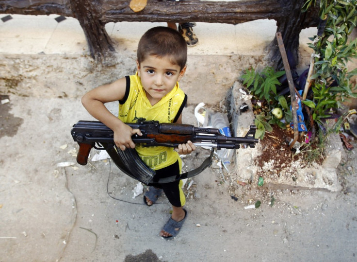 Children with guns walk the streets in war-torn Damascus PIC: Reuters