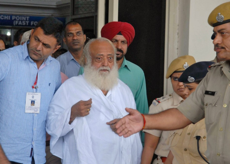 Asaram Bapu is led from Jodphur airport by police to face questioning.